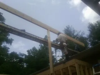 Carpenter setting a ridge beam over a new addition frame — Ice Dam Removal by Roofing Brothers in Hartwell