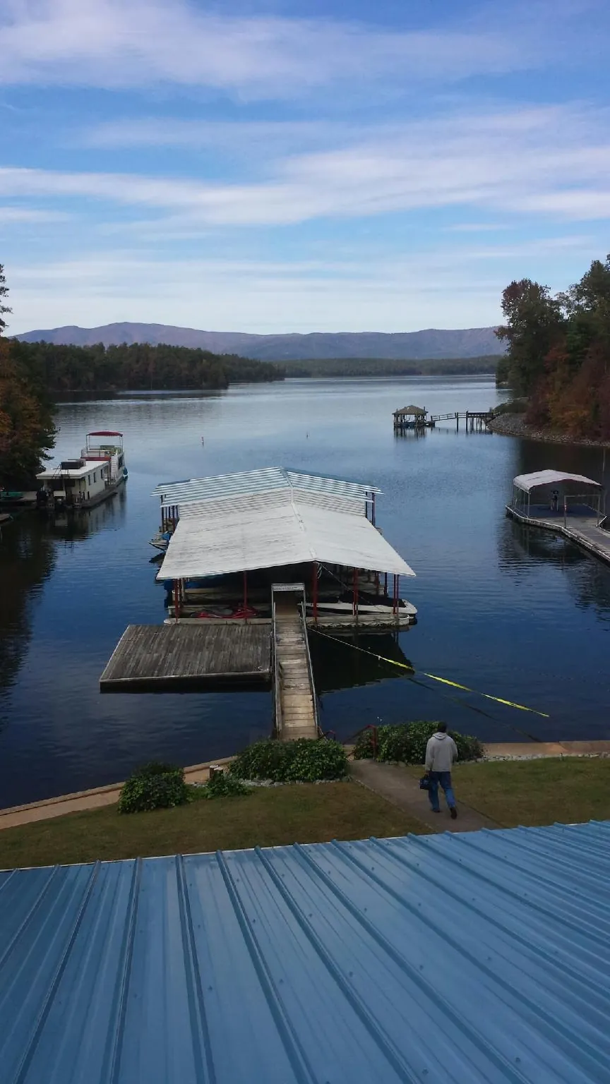 View across a lake from a newly installed blue metal roof in Hartwell