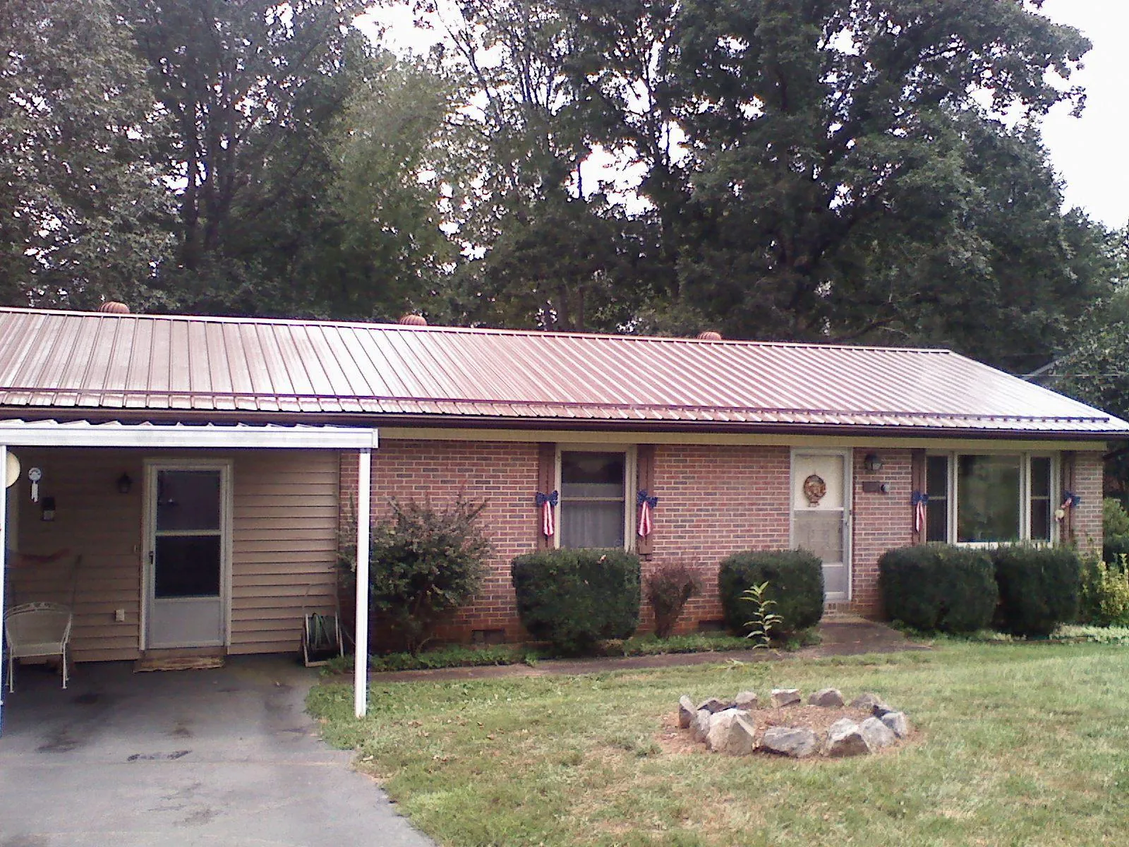 Bronze metal roof and carport on a brick ranch home — Roof Repair work by our crew in Hartwell